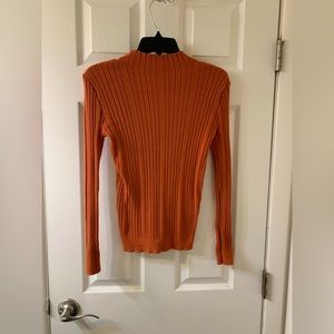 Woman’s orange long sleeve top